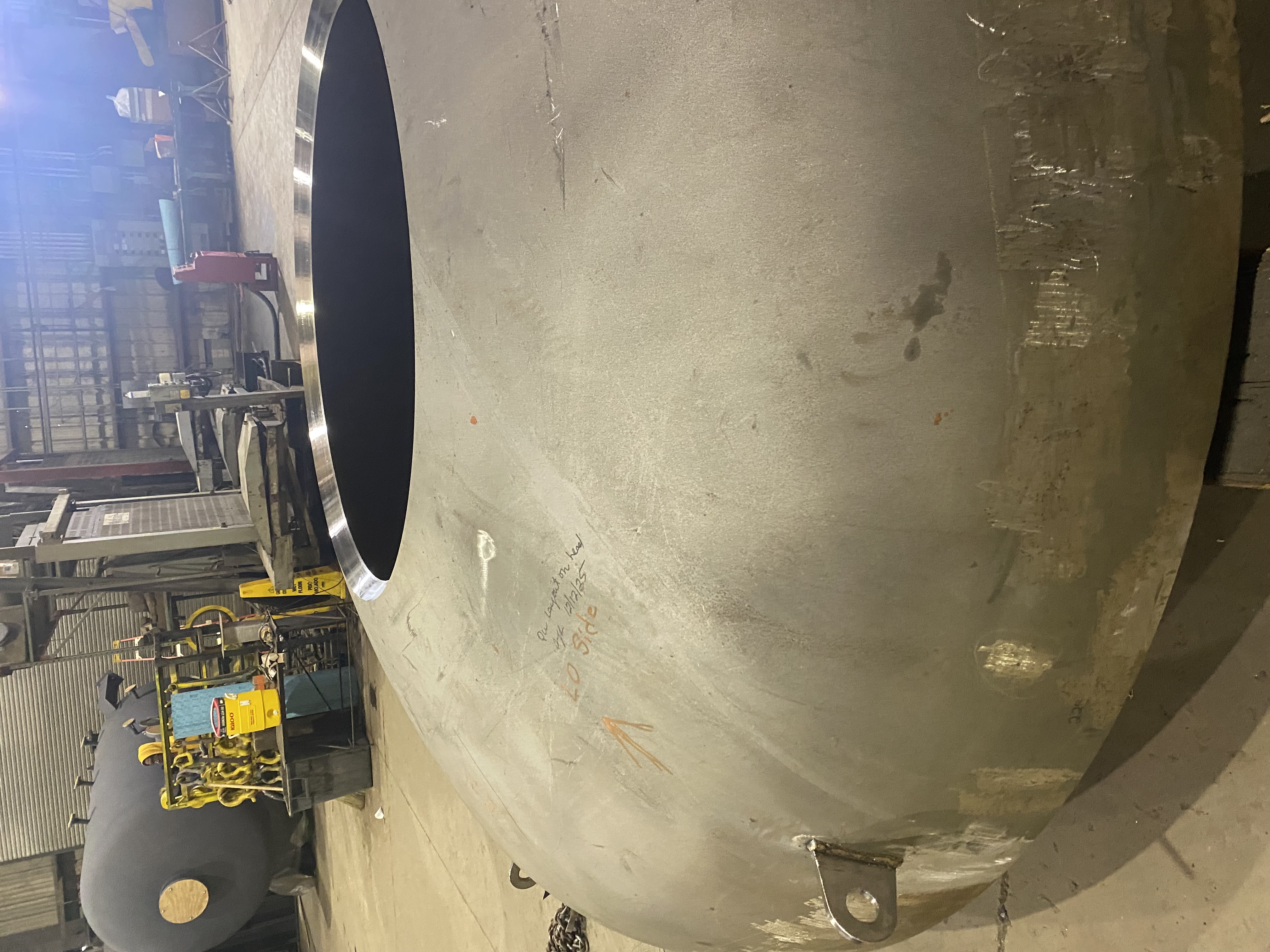 Beveled nozzle opening machined into a formed head